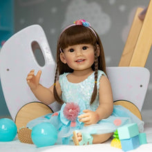 Realistic Reborn Toddler Doll in a blue skirt with toy accessories for imaginative play, nursery display, and birthday gifting.