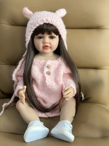 Realistic silicone Reborn Doll newborn girl close-up in a pink outfit and hat for baby doll collecting and presents.