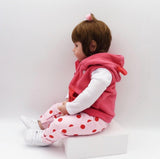 Child wearing a pink outfit with a hood and polka dot pants.