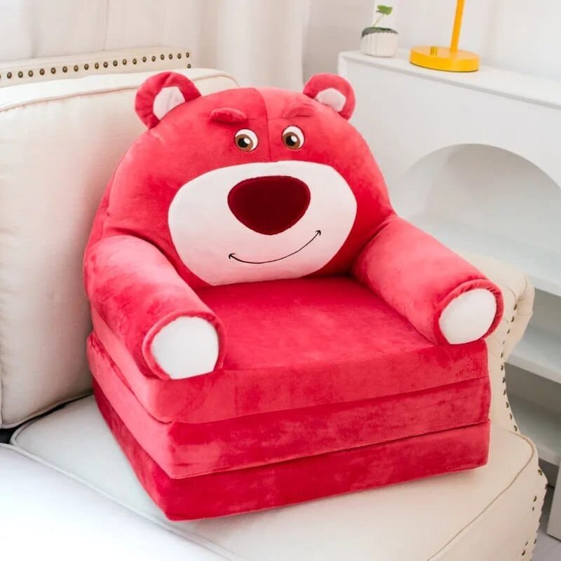 Red bear plush stuffed animal baby support seat placed in a nursery for babies learning to sit.