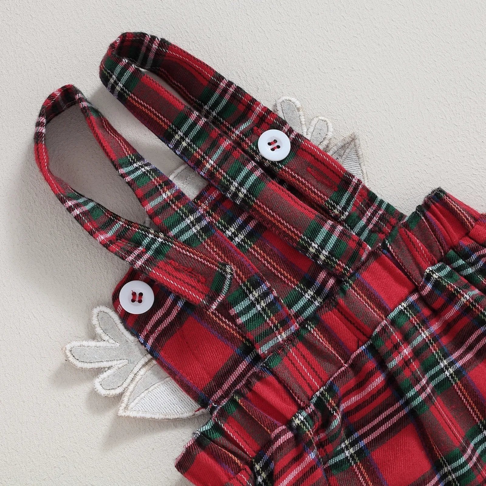 Red and green plaid baby skirt with white buttons for Christmas outfits and festive toddler dressing.