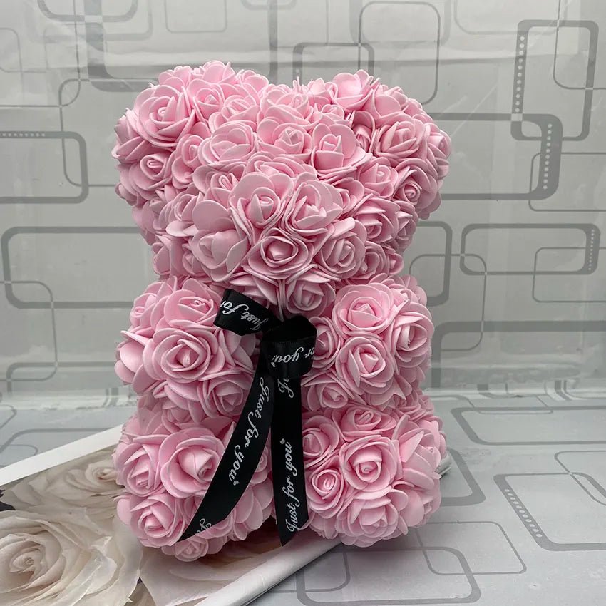 Pink rose teddy bear with a black ribbon.