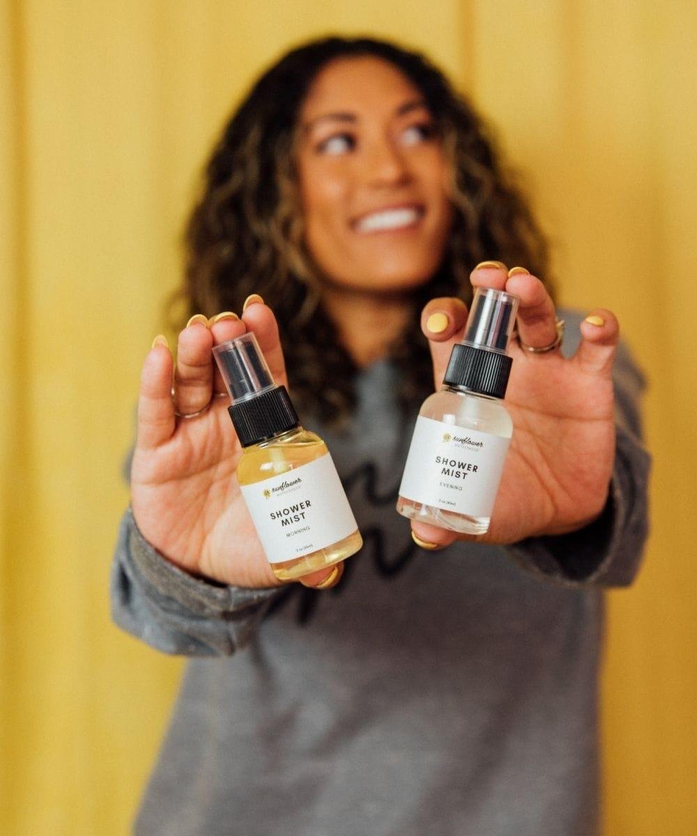 Woman holding two bottles of 'Shower Mist' 