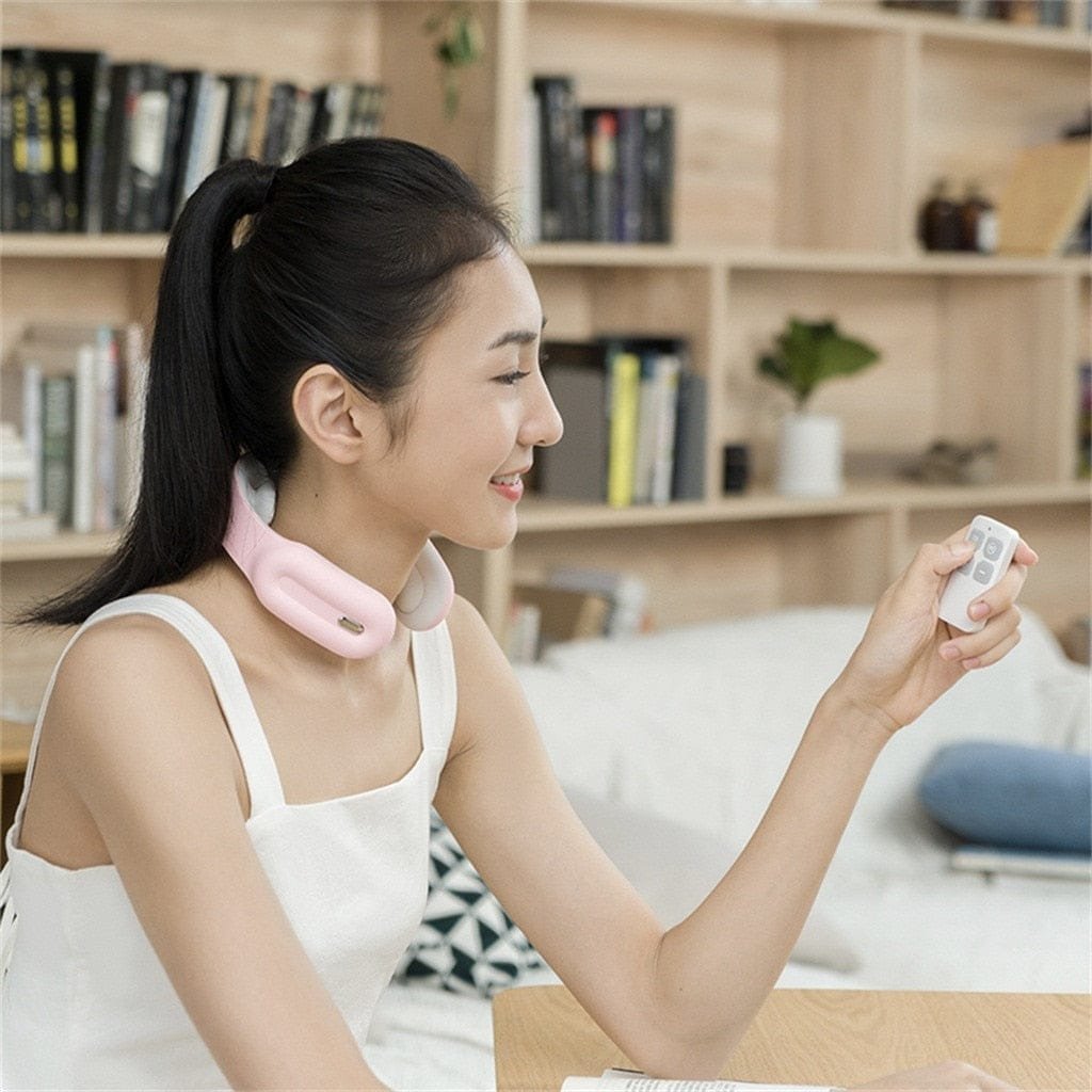 Remote-controlled neck and shoulder massager used while relaxing on the sofa for hands-free pain relief.