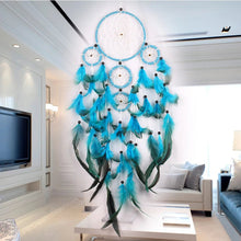 Rustic blue and green feather dream catcher styled in a modern living room for wall art.