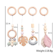 Baby teething toy with wooden rings and leaf-shaped beads, showing measurements and weight.