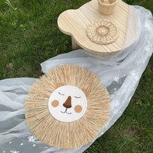 Scandinavian lion wall decor in handwoven cotton and straw, shown outdoors to highlight its natural fibres.