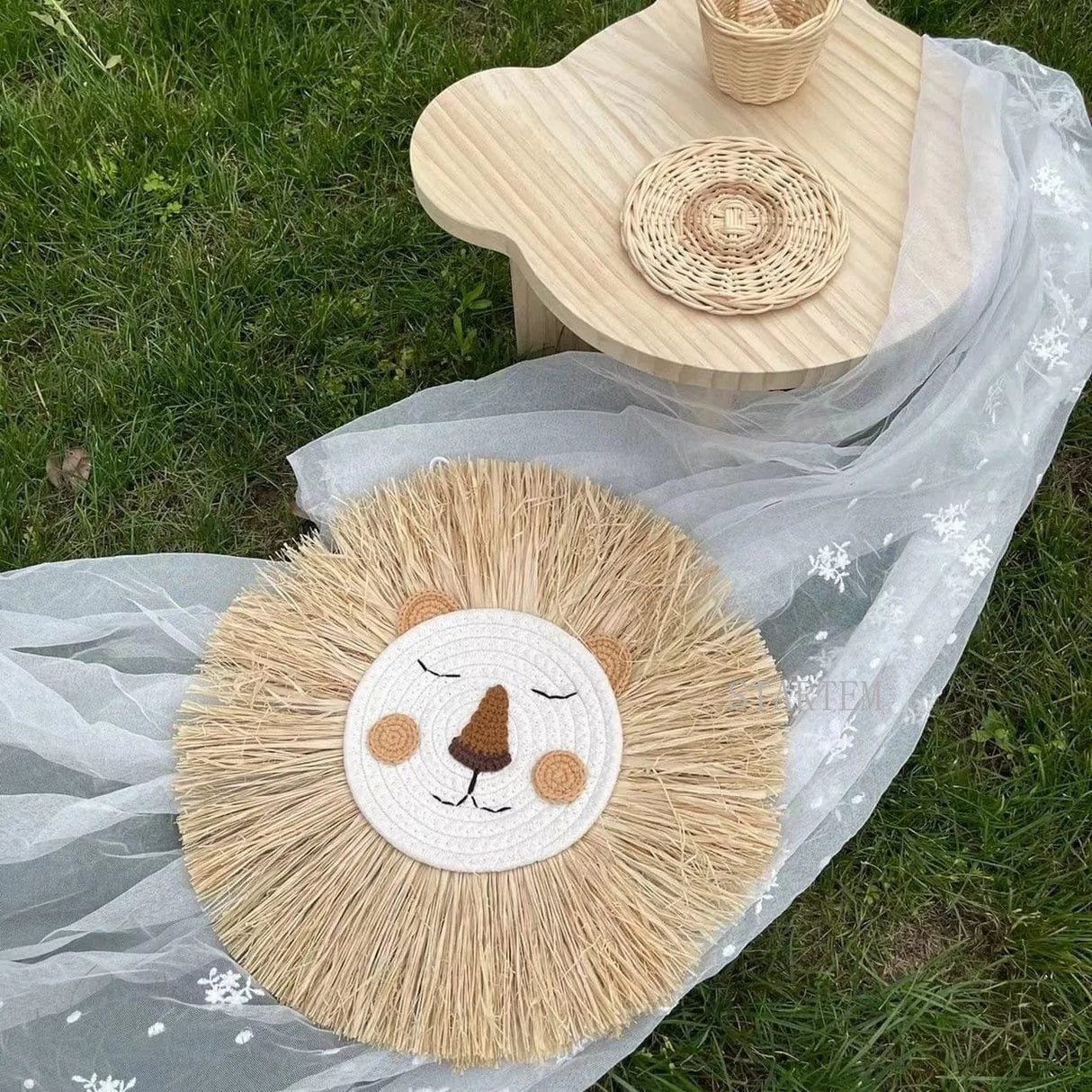 Round woven mat with lion design on a grassy surface
