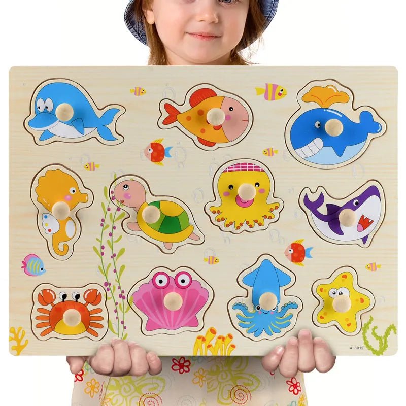 Child holding a Montessori wooden sea animal puzzle for independent play with colorful ocean illustrations.