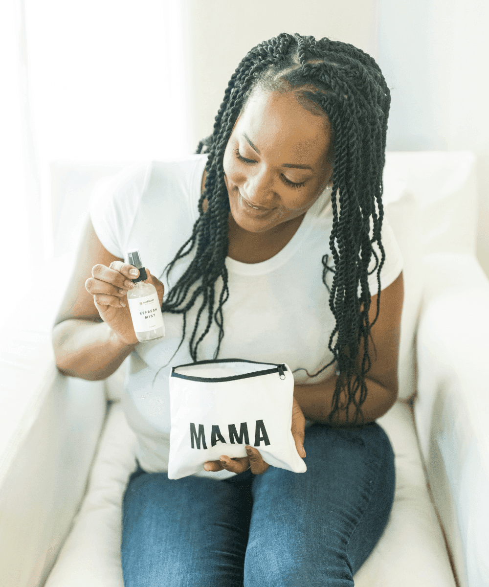 Woman holding a small pouch labeled 'MAMA' and a bottle of hand sanitizer.