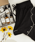 Self Care Night Bundle with a black pajama set and bath products for relaxing evenings, unwinding at home, and restful bedtime routines.