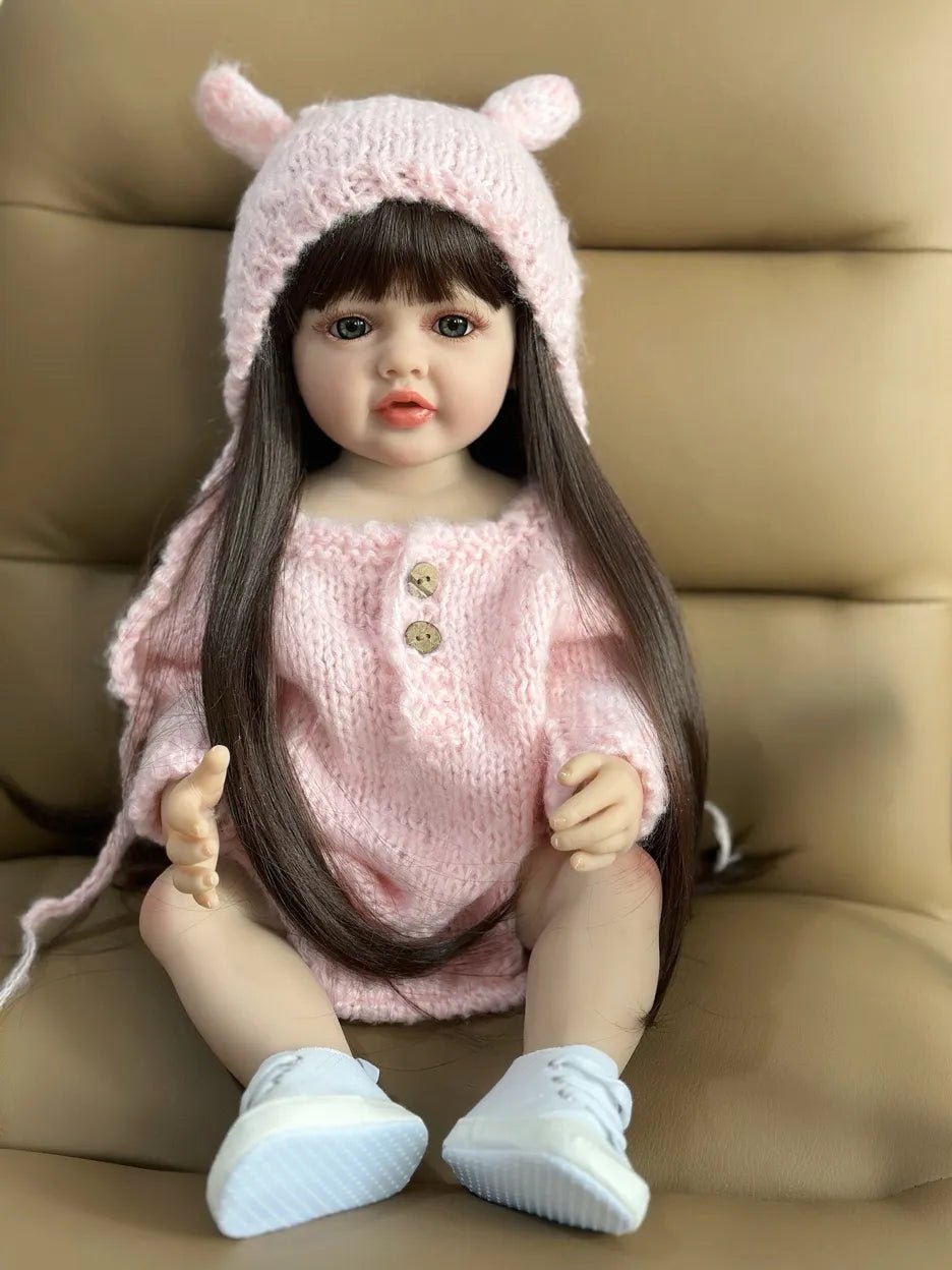 Silicone Reborn Doll newborn girl in a pink outfit and hat, a collectible baby doll for nursery display and gifting.
