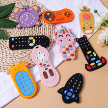 Silicone remote control baby teether toys in a styled flat lay for teething relief, baby gifting, and nursery play.