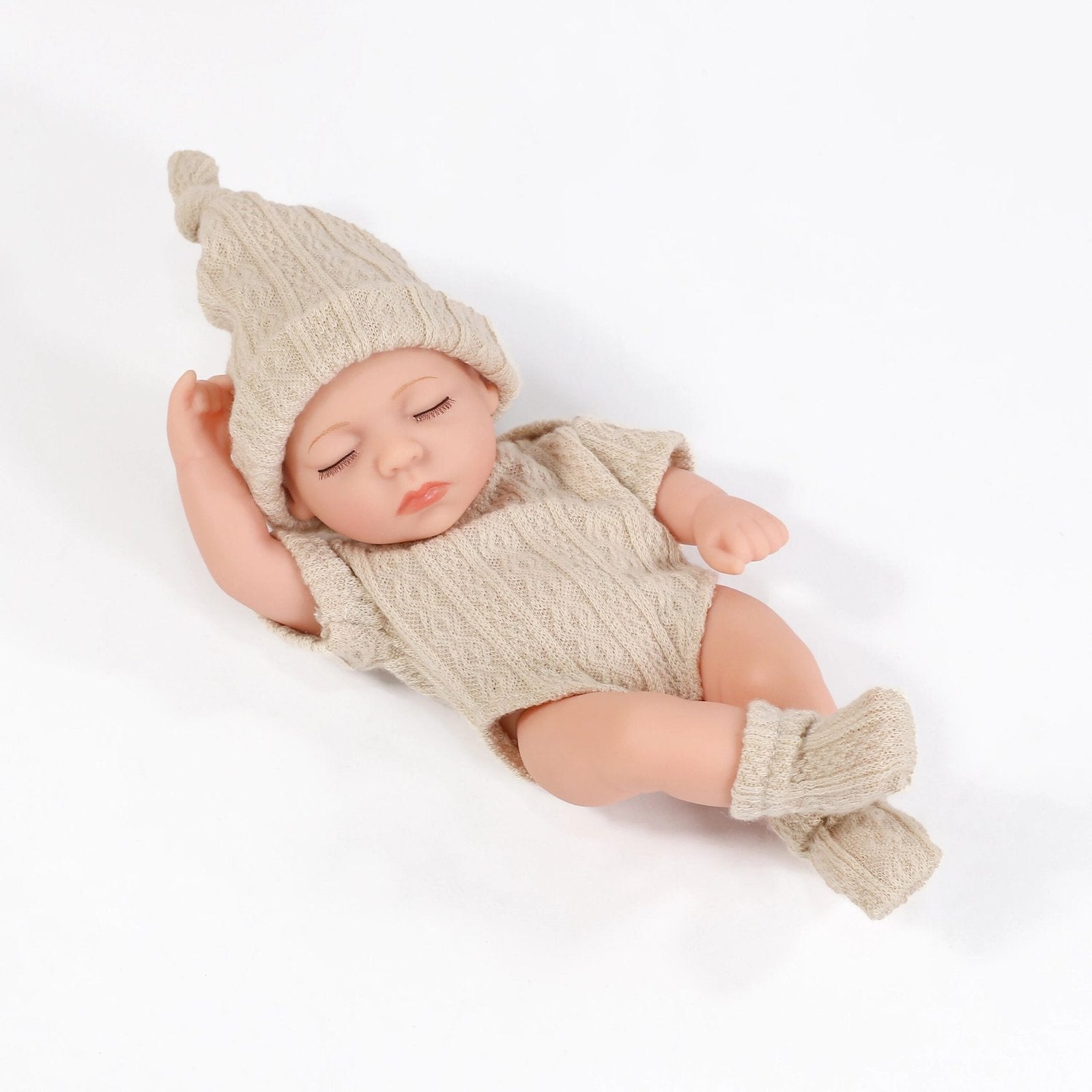 Newborn baby in a knitted outfit and hat on a white background