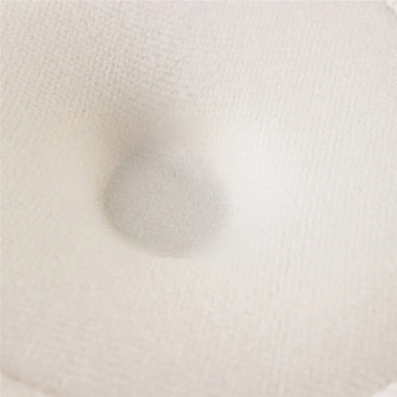 Close-up of the beige soft cotton nursing pad fabric, a washable absorbent layer for comfortable nursing wear.
