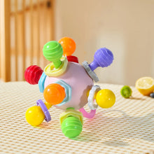 Lilac-pink grasping ball with colorful knobs on a woven tablecloth