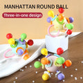 Three colorful grasping balls with textured knobs in blue, cream-yellow and lilac on a table