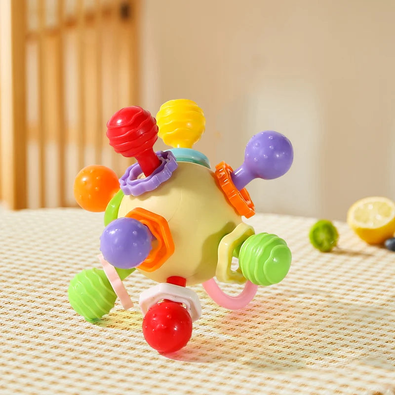 Cream-yellow grasping ball with colorful knobs on a woven tablecloth