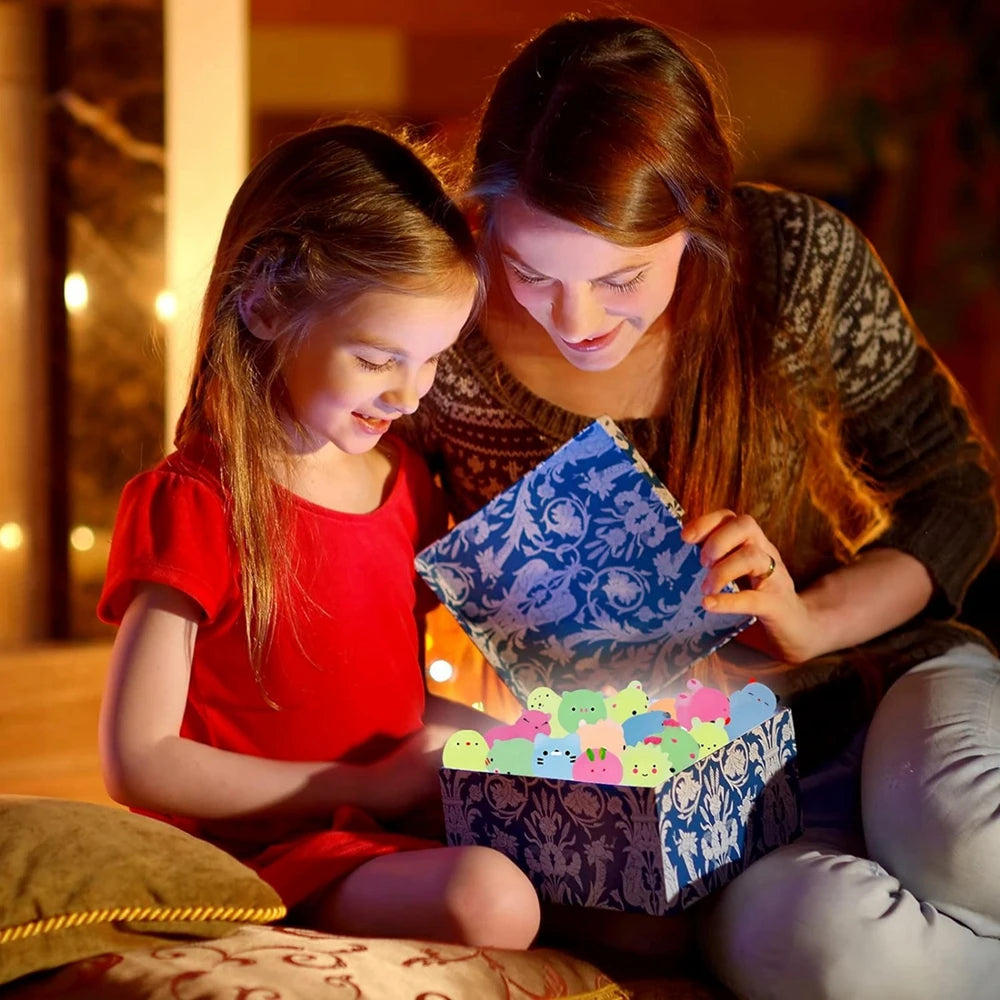Woman and young girl opening a gift box together in a warm, indoor setting.