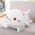 Cute white plush toy resembling a cat on a book.