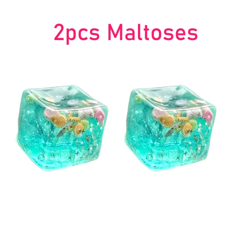 Two turquoise dice with sea-themed figures on a white background, labeled '2pcs Maltoses'.