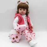 Child's doll wearing a pink outfit with a matching plush toy.