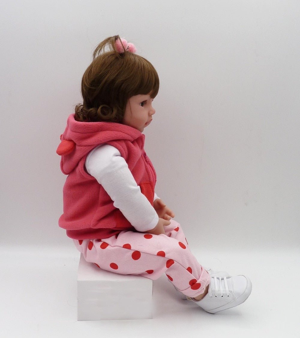 A child-like doll wearing a pink outfit.