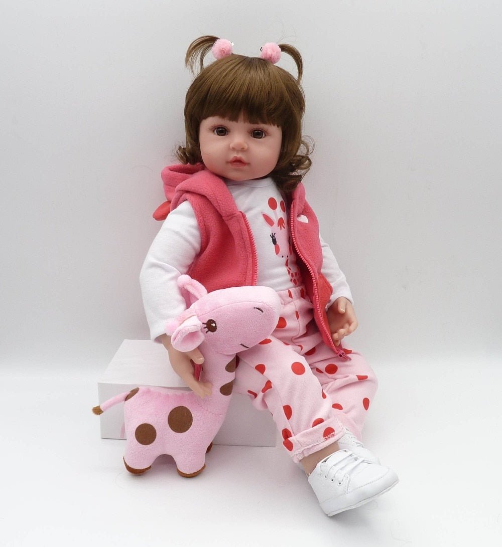 Child's doll in pink outfit with a small pink and brown toy on a white background