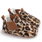 Pair of leopard print baby shoes with brown accents.