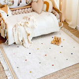 Children's room with a crib, plush toys, and a polka dot rug.