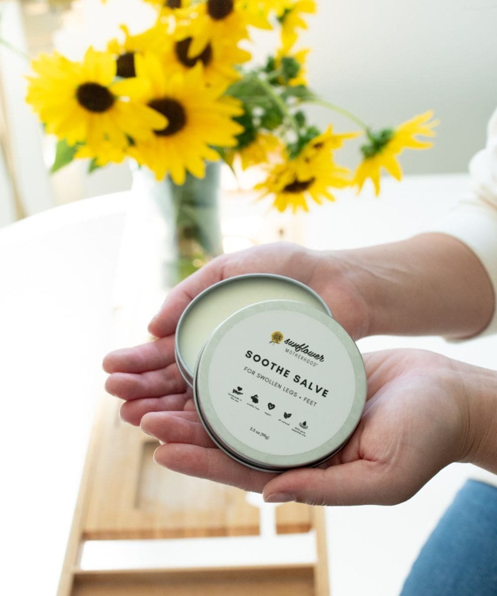 Hand holding a container of 'Soothe Salve' 