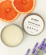 Soothe Salve container with a lid, grapefruit slices, and lavender flowers 