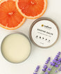 Soothe Salve container with a lid, grapefruit slices, and lavender flowers 