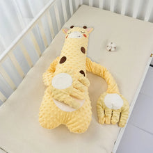 Yellow giraffe plush pillow on a crib mattress, second view