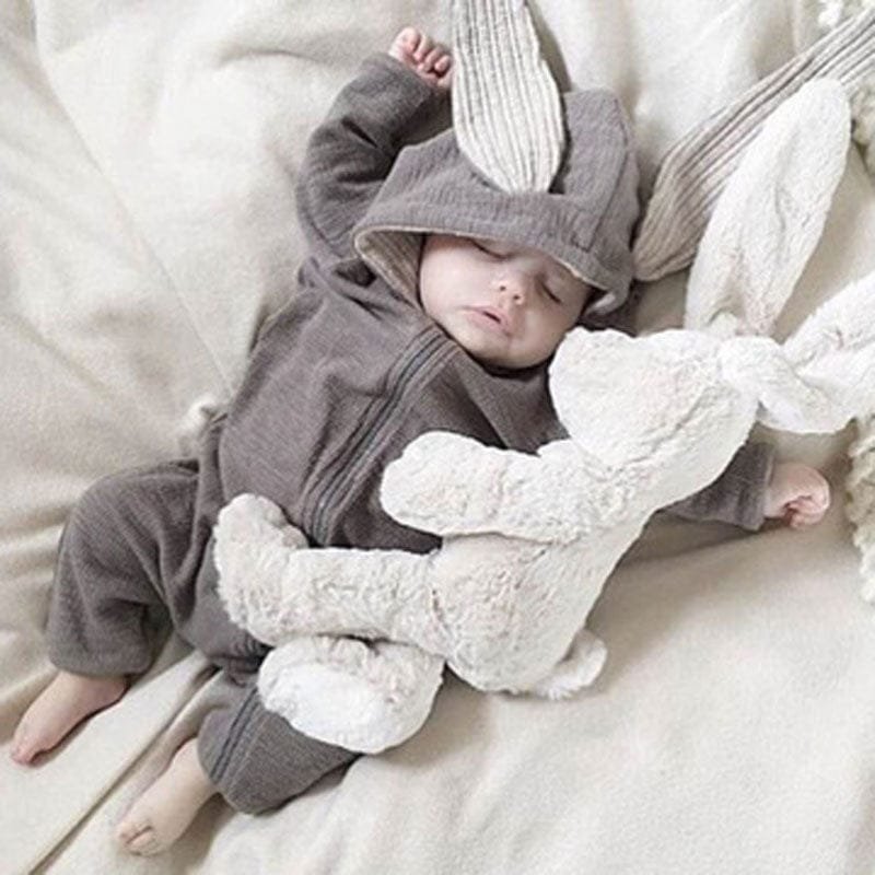 Spring Autumn Newborn Baby Clothes bunny ear romper worn by a baby with a plush toy for cosy daily wear and nursery photos.