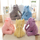 Five colorful elephant plush toys on a light wooden floor.
