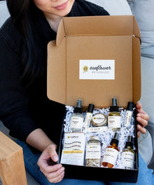 Deluxe Self Care Gift Box held in hand showcasing the Sunflower Motherhood skincare set for gifting.