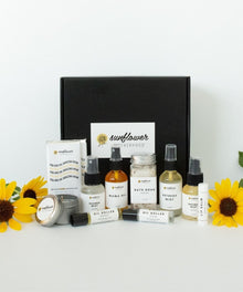 Deluxe Self Care Gift Box flat lay of skincare and wellness items in sunflower packaging.