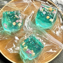 Three pieces of turquoise resin art with decorative elements on a wooden surface.