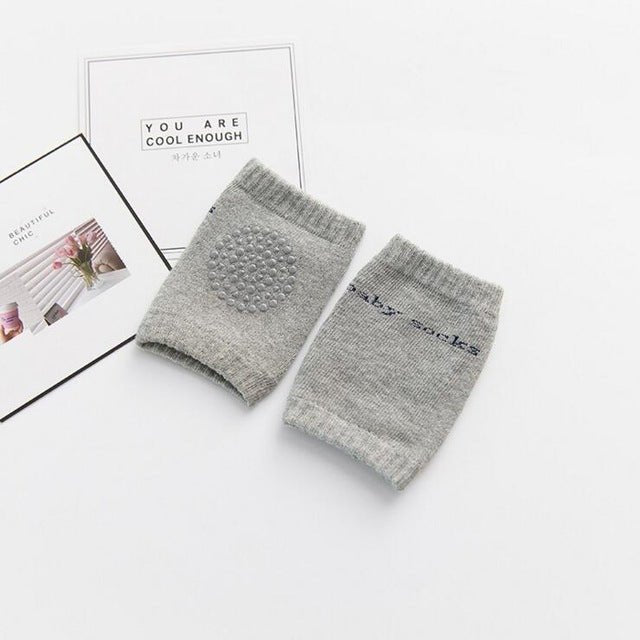 Thick padded grey baby knee pads for extra cushioning while crawling on wooden and concrete floors.