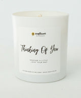 White candle with a label reading 'Thinking Of You' 