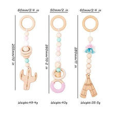 Three wooden baby teething toys with size guide for rotating sensory play on the activity gym.