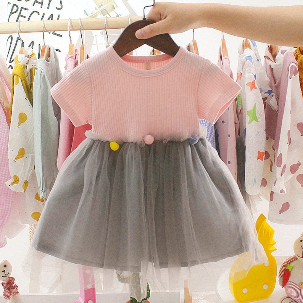 Toddler girls pink top and grey tulle patchwork dress on a hanger for parties, playdates, and casual outings.