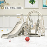 Children's playground set with slide and climbing structure on a light wooden floor.