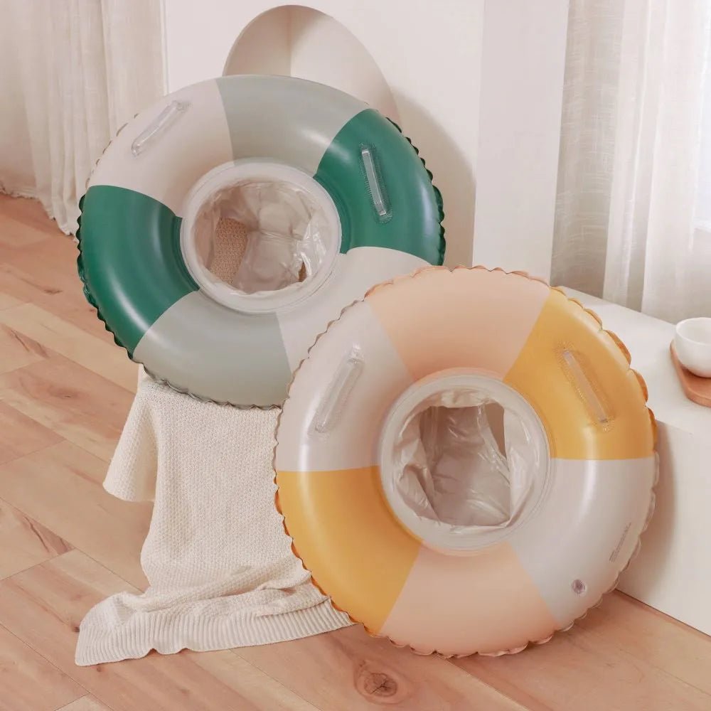 Two colorful inflatable rings on a wooden floor with a neutral background