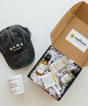 Gift box with skincare products, a cap, and a card 