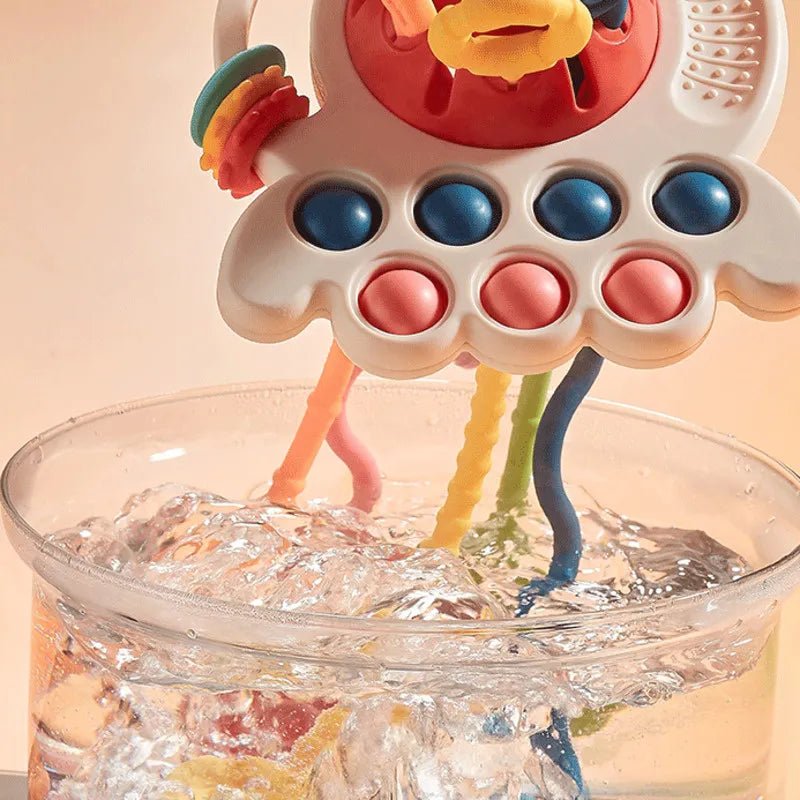 Colorful bubble pop toy with a glass of water and ice cubes.