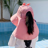 Person wearing a pink horse-shaped hat by a pool