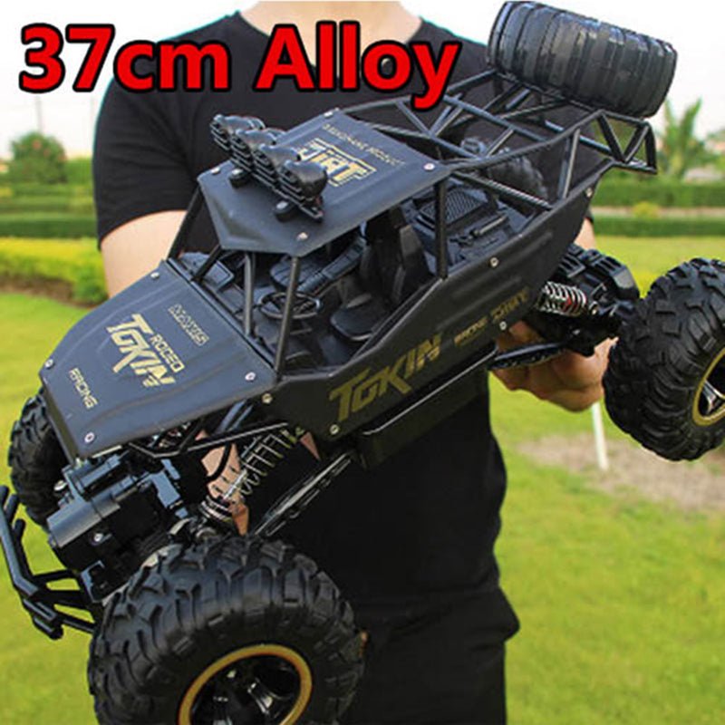 Tokin 2.4G RC truck with alloy body held by hand showing remote control operation.