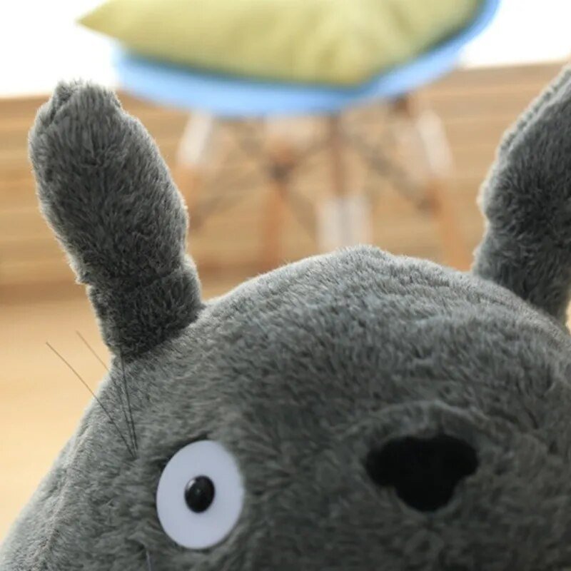 Totoro anime character plush doll face detail, a soft toy for kids cuddling and comforting bedtime routines.